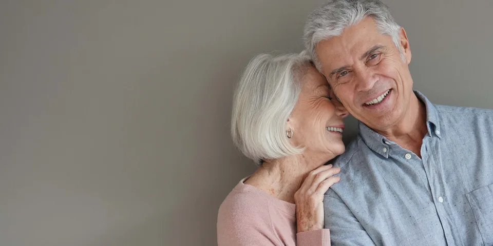 Smiling elderly couple showing results after dental implants treatment in Dublin